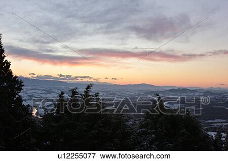 Sunrise over Tiber valley with grey pink and golden sky in the early morning mist of winter, with tree outline in foreground, and River Tiber curving through snow-covered valley View Large Photo Image Stock Photo - Sunrise over Tiber valley with grey pink and golden sky in the early morning mist of winter, with tree outline in foreground, and River Tiber curving through snow-covered valley . Fotosearch