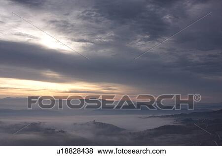 Stock Photo - Sunrise over Tiber valley with grey pink and golden sky in the early morning mist of winter. Fotosearch