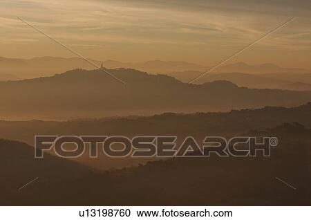 Sunrise over Tiber valley with orange and golden sky in the early morning mist of winter, and hilltop town of Todi in distance View Large Photo Image Stock Image - Sunrise over Tiber valley with orange and golden sky in the early morning mist of winter, and hilltop town of Todi in distance. Fotosearch