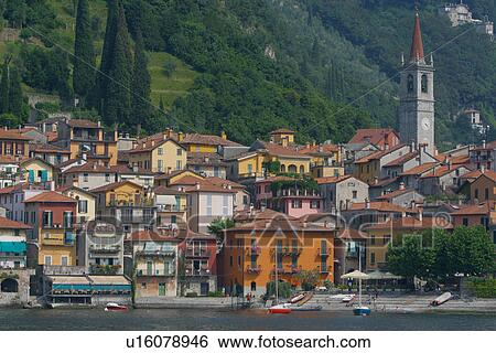 Varenna, view of harbour from water, sail boat moored, church bell tower and mountain slope in background View Large Photo Image Stock Photograph - Varenna, view of harbour from water, sail boat moored, church bell tower and mountain slope in background. Fotosearch