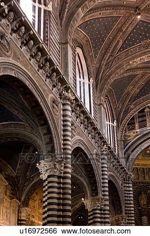 View Of Central Nave And Vaulted Ceiling Of Siena Duomo With Black And White Striped Columns Rib Vaulted Blue Painted Ceiling With Gold Stars And