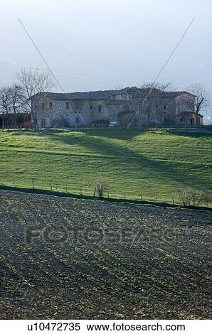 Stock Photography -  View of farmer's fields, and farmhouse, with early crops in springtime, Le Marche, Italy. Fotosearch