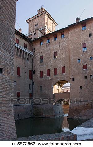 Stock Photo - View of one of the 4 towers of Castello Estense, with ramparts and moat filled with water. Fotosearch