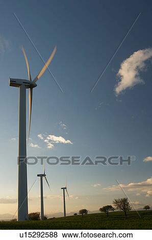 view of wind turbines, on grassy hill, in Southern Italy at sunset, against blue sky View Large Photo Image Stock Photo - view of wind turbines, on grassy hill, in Southern Italy at sunset, against blue sky. Fotosearch