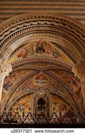 Stock Image - View upwards of Chapel of Last Judgement by Luca Signorelli, with ornate wrought iron railing and stone archway in foreground. Fotosearch
