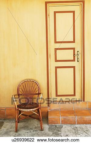 Stock Image - Armchair in front of a house. Fotosearch