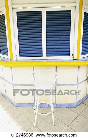 Stock Photograph - Chair in front of a closed store. Fotosearch