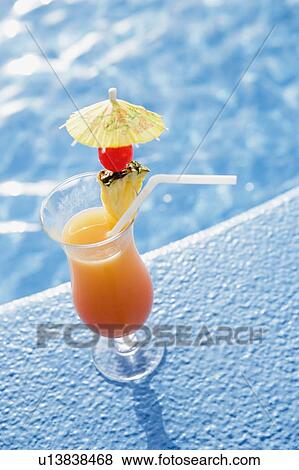 Close-up of a glass of pineapple juice on the ledge of a swimming pool View Large Photo Image Stock Photo - Close-up of a glass of pineapple juice on the ledge of a swimming pool. Fotosearch