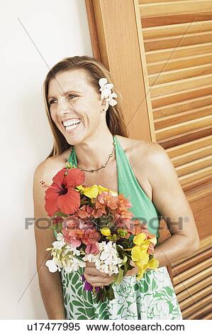 Stock Photography - Close-up of a mid adult woman holding a bouquet of flowers. Fotosearch