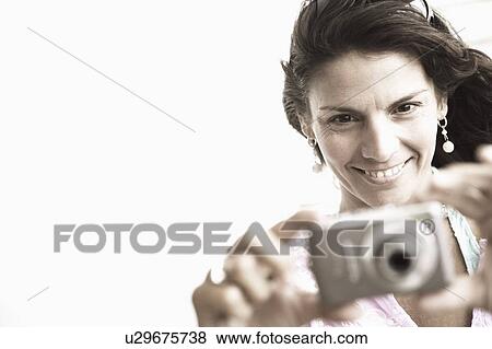 Close-up of a mid adult woman taking a picture with a digital camera View Large Photo Image Stock Photo - Close-up of a mid adult woman taking a picture with a digital camera. Fotosearch
