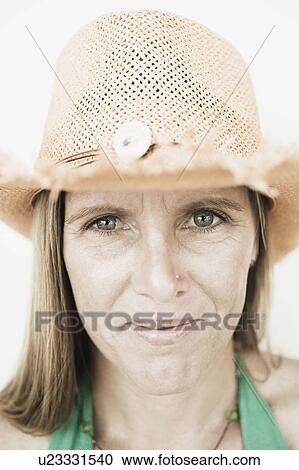 Close-up of a mid adult woman wearing a straw hat View Large Photo Image Stock Image - Close-up of a mid adult woman wearing a straw hat. Fotosearch
