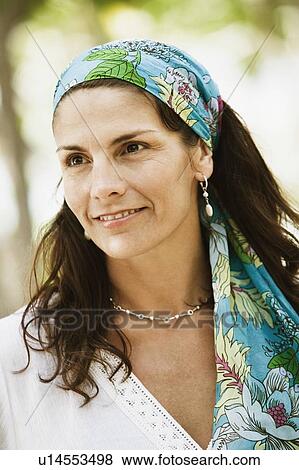 Close-up of a mid adult woman wearing a headscarf and smiling View Large Photo Image Stock Photo - Close-up of a mid adult woman wearing a headscarf and smiling. Fotosearch
