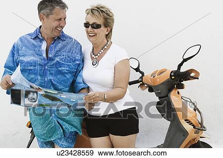 Close-up of a senior man and a mature woman holding a catalog and smiling View Large Photo Image Stock Photo - Close-up of a senior man and a mature woman holding a catalog and smiling. Fotosearch