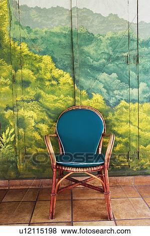 Stock Photo - Close-up of an armchair in front of a painted door. Fotosearch
