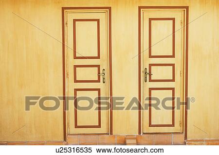 Stock Photography - Close-up of closed doors of two houses. Fotosearch