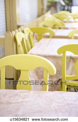 Stock Image - Close-up of empty tables and chairs in a restaurant. Fotosearch