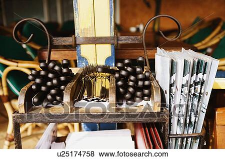 Stock Photo - Close-up of forks and knives with menus on a shelf in a restaurant. Fotosearch