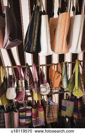 Stock Image - Close-up of hand bags and purses hanging at a market stall. Fotosearch