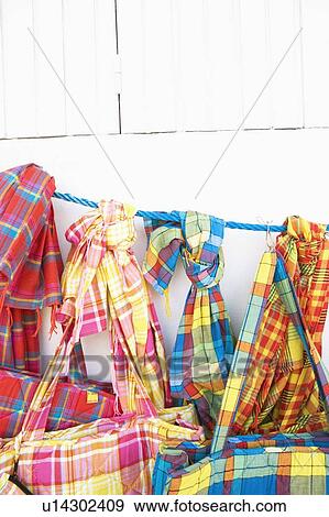Stock Photo - Close-up of hand bags and stoles hanging at a market stall. Fotosearch