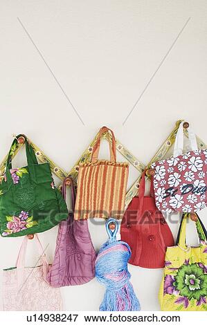 Stock Photo - Close-up of hand bags hanging in a store. Fotosearch