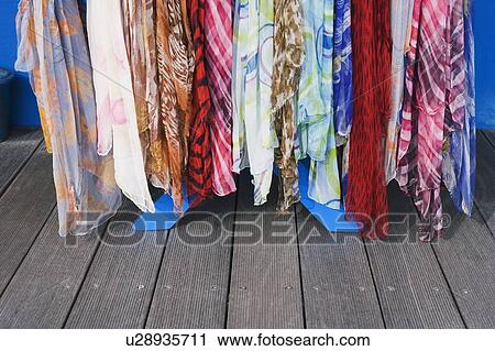 Stock Image - Close-up of scarves hanging at a market stall. Fotosearch