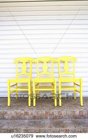 Close-up of three empty chairs in a row in front of a store View Large Photo Image Stock Photo - Close-up of three empty chairs in a row in front of a store. Fotosearch