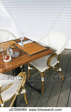 Picture - Empty chairs and a table at a sidewalk cafe. Fotosearch