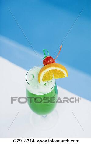 Picture - High angle view of a glass of cocktail at the poolside. Fotosearch