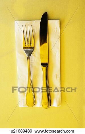 Stock Photo - High angle view of a table knife with a fork on a napkin. Fotosearch