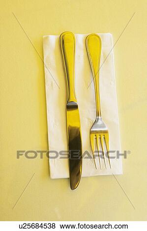 Stock Photo - High angle view of a table knife with a fork on a napkin. Fotosearch