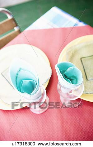 Stock Image - High angle view of stem glasses and plates on a table. Fotosearch