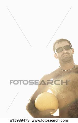 Low angle view of a mid adult man holding a beach volleyball View Large Photo Image Stock Image - Low angle view of a mid adult man holding a beach volleyball. Fotosearch