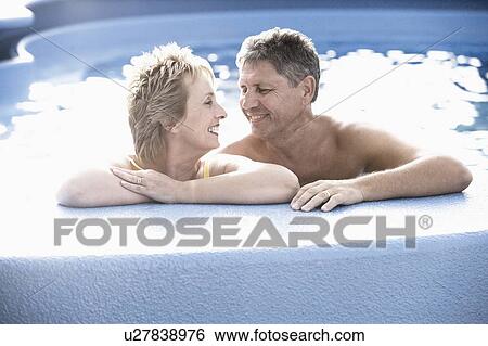 Stock Photograph - Mature woman and a senior man smiling in a swimming pool. Fotosearch