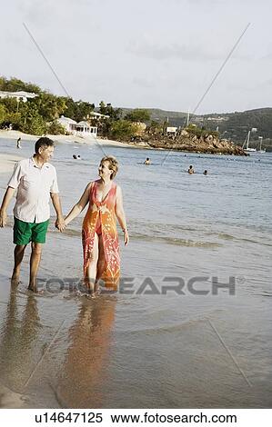 Mature woman holding a senior man's hand and walking on the beach View Large Photo Image Stock Photography - Mature woman holding a senior man's hand and walking on the beach. Fotosearch