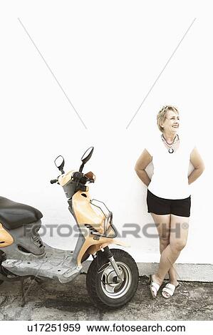 Mature woman leaning against a wall and smiling View Large Photo Image Stock Photo - Mature woman leaning against a wall and smiling. Fotosearch