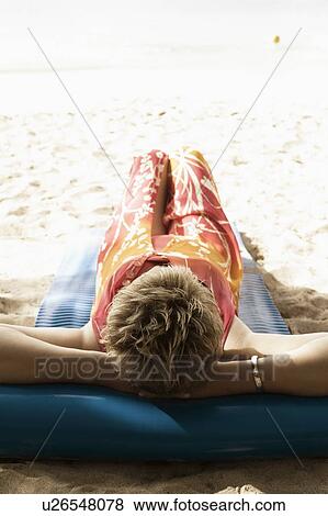 Mature woman lying on a float on the beach View Large Photo Image Stock Photo - Mature woman lying on a float on the beach. Fotosearch