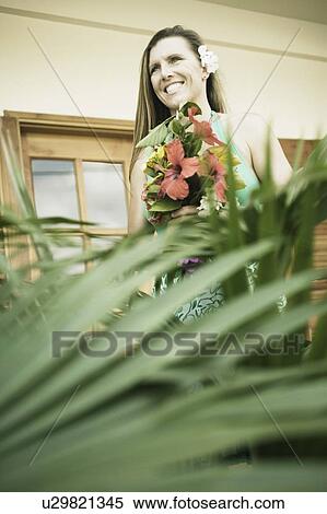 Mid adult woman holding a bouquet of flowers View Large Photo Image Stock Photography - Mid adult woman holding a bouquet of flowers. Fotosearch