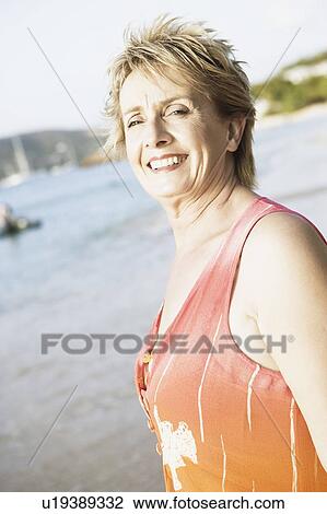 Portrait of a mature woman smiling on the beach View Large Photo Image Stock Image - Portrait of a mature woman smiling on the beach. Fotosearch