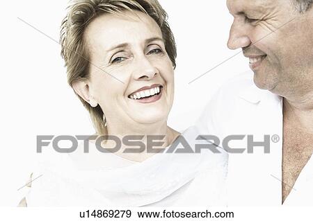 Portrait of a mature woman smiling with a senior man looking at her View Large Photo Image Stock Photo - Portrait of a mature woman smiling with a senior man looking at her. Fotosearch