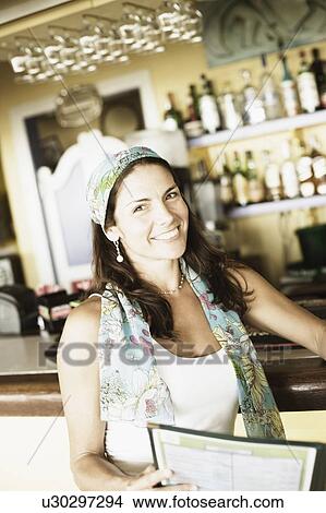 Portrait of a mid adult woman at a bar counter and smiling View Large Photo Image Picture - Portrait of a mid adult woman at a bar counter and smiling. Fotosearch