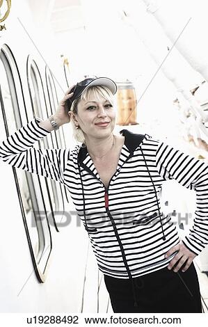 Portrait of a young woman smirking with her hands on her hip on the deck of a cruise ship View Large Photo Image Stock Image - Portrait of a young woman smirking with her hands on her hip on the deck of a cruise ship. Fotosearch