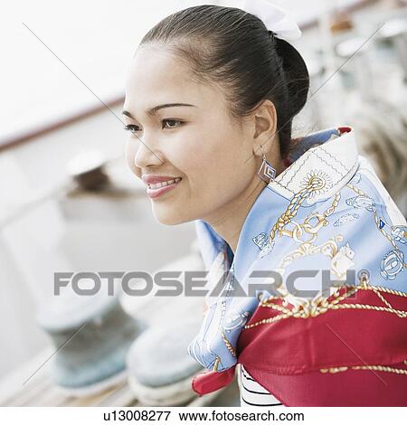 Stock Photo - Side profile of a young woman smiling. Fotosearch