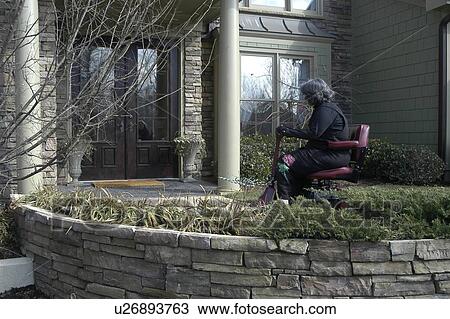 A woman using a wheelchair wheels toward the front door of a friend’s house. View Large Photo Image Stock Image - A woman using a wheelchair wheels toward the front door of a friend’s house.. Fotosearch
