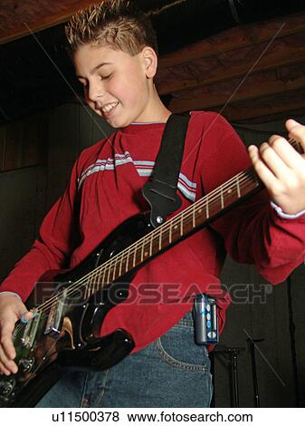 Stock Photo - A young boy with diabetics enjoys playing on his guitar.. Fotosearch