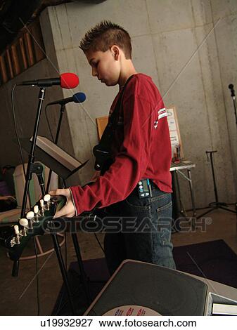 Stock Photo - A young boy with diabetics enjoys playing on his guitar.. Fotosearch