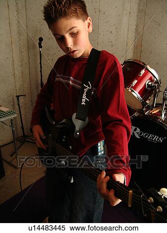 Stock Photography - A young boy with diabetics enjoys playing on his guitar.. Fotosearch