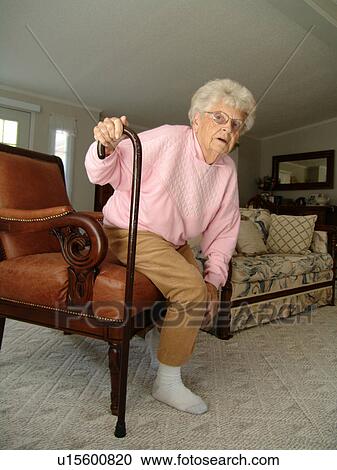 An elderly woman gets up after some quit time in her living room. View Large Photo Image Stock Image - An elderly woman gets up after some quit time in her living room.. Fotosearch