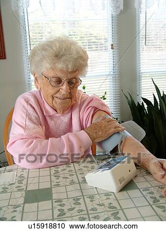 An elderly woman takes her daily blood pressure reading. View Large Photo Image Stock Image - An elderly woman takes her daily blood pressure reading.. Fotosearch