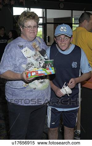 Stock Photography - Boy with disabilities and friend getting their popcorn and coke for the movies.. Fotosearch