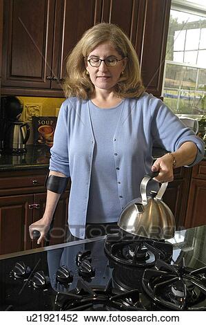 Female with arm crutches prepares the morning coffee. View Large Photo Image Stock Image - Female with arm crutches prepares the morning coffee.. Fotosearch